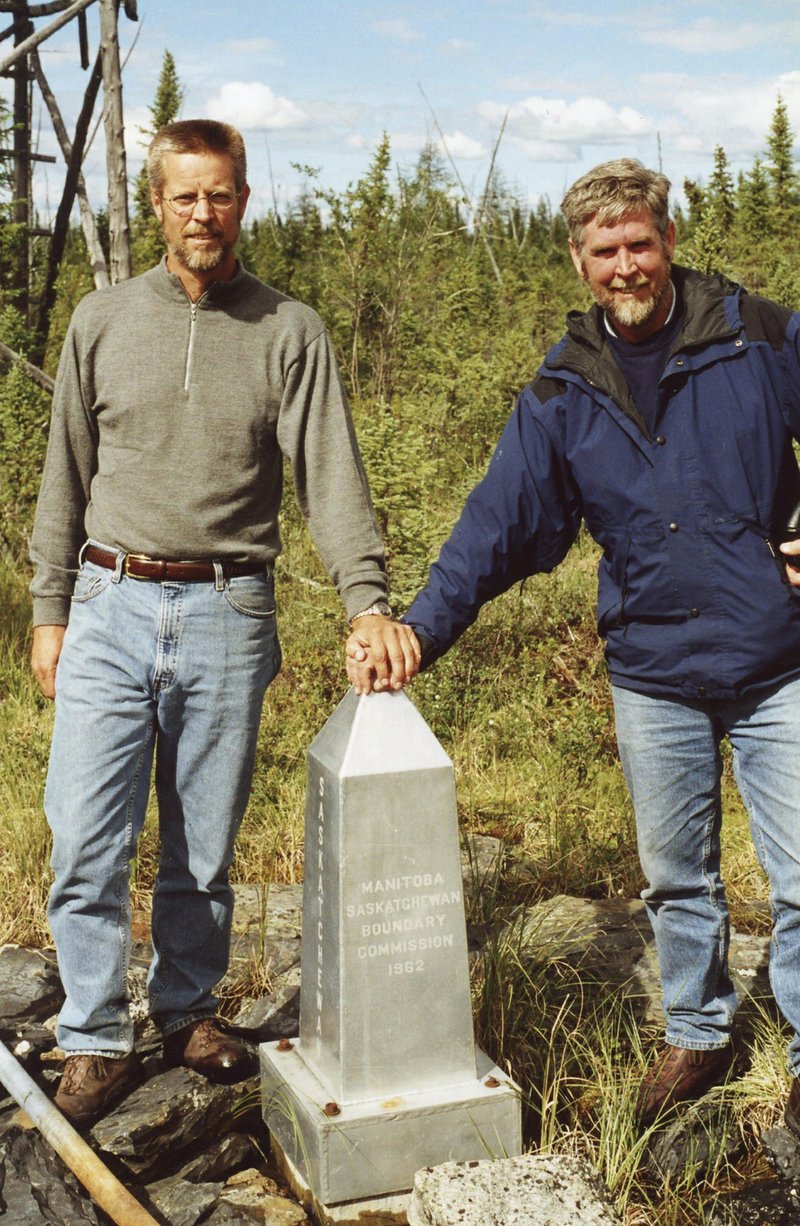 In this undated photo provided by Brian Butler, Butler of Holliston, Mass., left, and his brother Gregg stand at the monument marking the spot where Saskatchewan, Manitoba, the Northwest Territories and Nunavut meet. Such remote corners have become destinations for adventurist tourists such as Brian. (Courtesy of Brian Butler via AP)