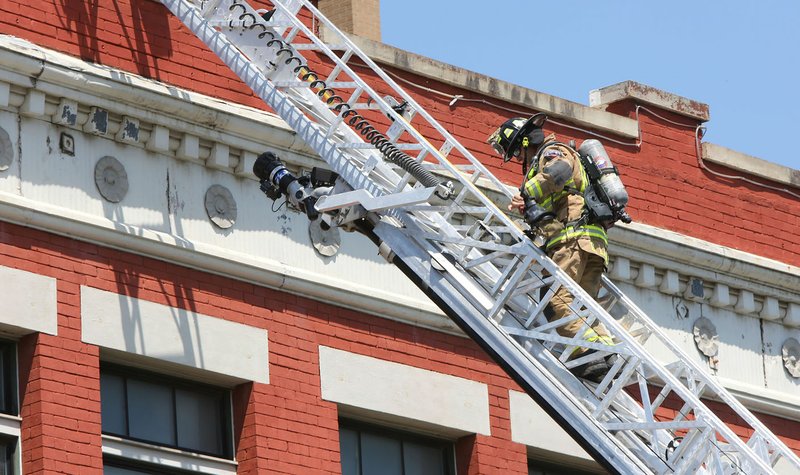 NWA Democrat-Gazette/DAVID GOTTSCHALK Members of the Fayetteville Fire Department respond July 7 to the report of smoke in a building in downtown Fayetteville. The smoke was result of working being done in the building.