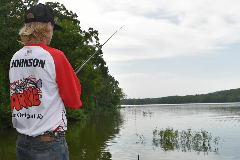 Despite fishing at reservoirs all over the region, Prairie Grove's Dalton Johnson said Bob Kidd Lake remains one of his favorite places to fish. Above, he works a plastic worm around some half-submerged vegetation at Bob Kidd Lake on Wednesday, July 26, 2017. 