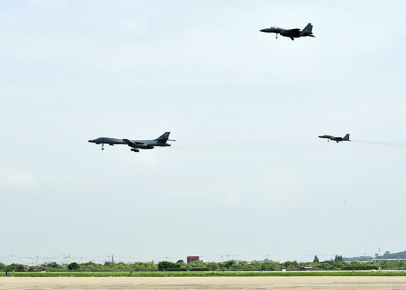 In this photo provided by South Korea Defense Ministry, a U.S. Air Force B-1B bomber (left) flies with South Korean F-15K fighter jets over Osan Air Base in Pyeongtaek, South Korea, on Sunday.