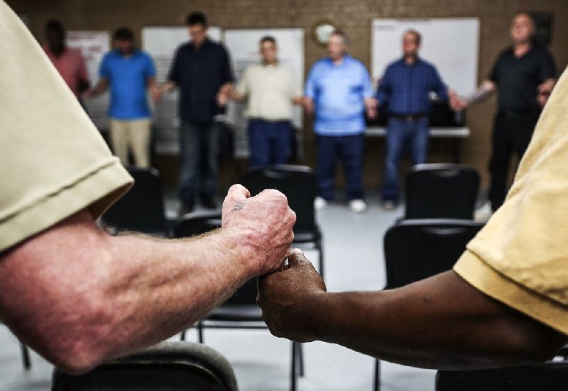 Prisoners in the Covenant Recovery Re-entry Program in Malvern say a prayer at the end of their session on July 20.