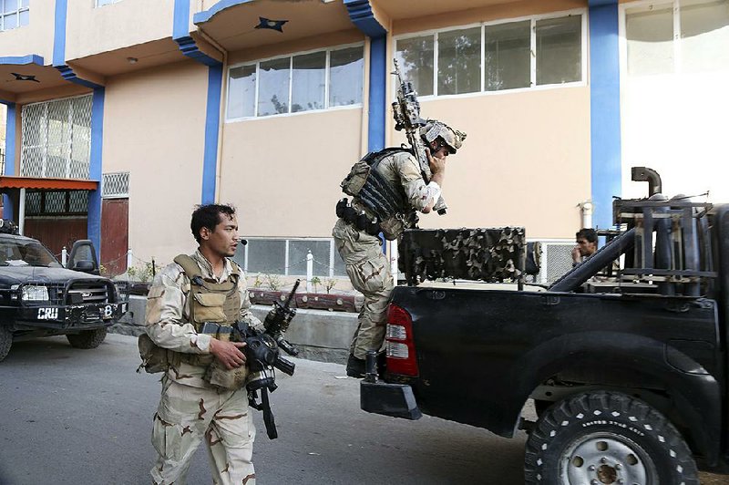 Security forces leave after a suicide attack followed by a clash between Afghan forces and Islamic State fi ghters during an attack on the Iraqi embassy in Kabul, Afghanistan.