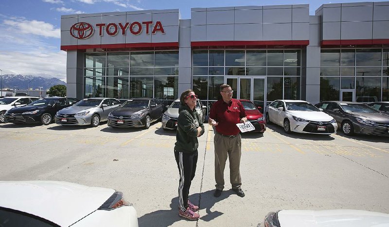 A shopper visits with a salesman for Mark Miller Toyota in Salt Lake City, in June. Toyota’s sales of new cars and trucks rose 3.6 percent in July, bucking the trend of lower sales for U.S. automakers. 