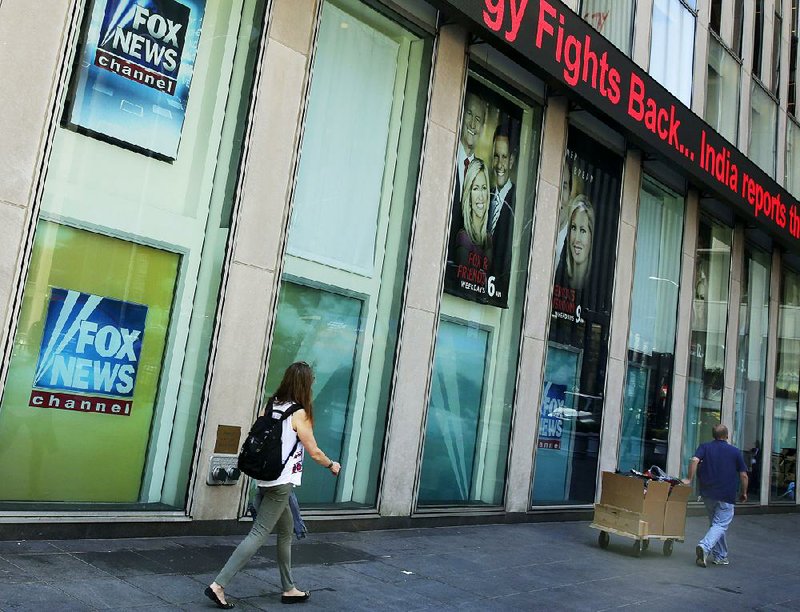 Pedestrians pass the News Corp. headquarters building and Fox News studios in New York on Tuesday. Fox contributor Rod Wheeler, who looked into the death of former Democratic National Committee staff member Seth Rich, has filed a lawsuit against Fox. 