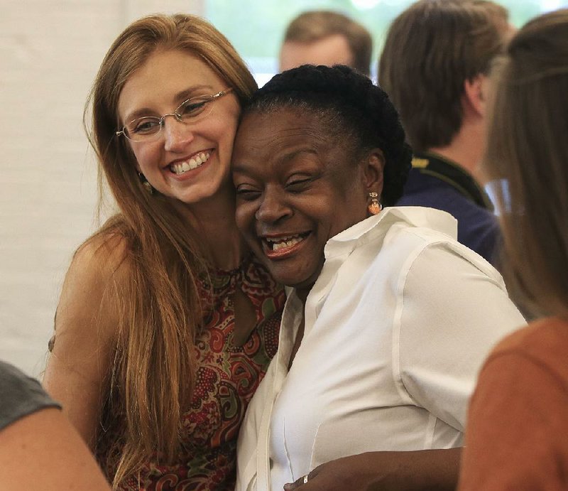 Georgia Mjartan (left), Our House executive director, hugs Cynthia Huff, who completed the Central Arkansas Family Stability Institute program, at Tuesday’s event at Our House in Little Rock. 