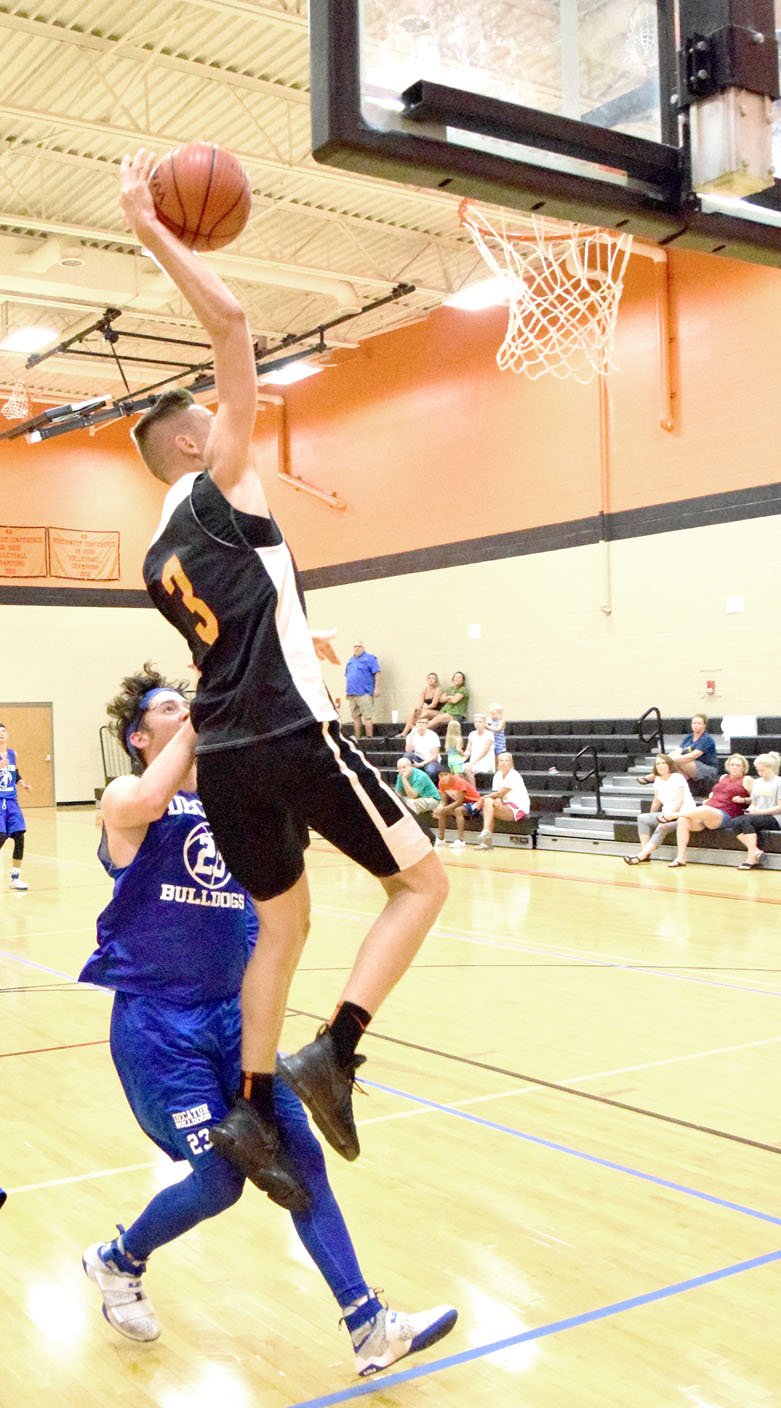 Photo by Mike Eckels Dayten Wishon (Gravette 3) attempted a dunk against Decatur&#8217;s Levi Newman (23) during the Bulldog-Lion basketball contest in the new gym at Gravette High School July 25. Wishon&#8217;s shot hit the front lip of the basket and was rebounded by Newman.