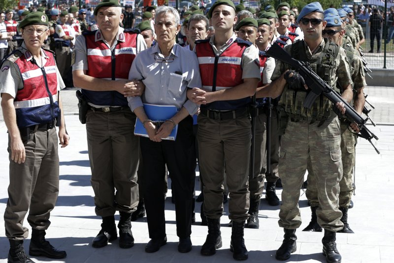 Paramilitary police and members of the special forces escort former Air Force commander Akin Ozturk and other suspects of last year's failed coup, outside the courthouse at the start of a trial, in Ankara, Turkey, Tuesday, Aug. 1, 2017. Nearly 500 suspects, including a number of generals and military pilots, went on trial in Turkey Tuesday accused of leading last year's failed coup attempt and carrying out attacks from an air base in Ankara. (AP Photo/Burhan Ozbilici)