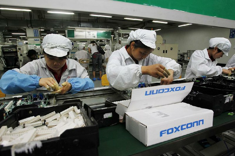 Employees work on the production line at the Foxconn Technology Group complex in the southern Chinese city of Shenzhen in this file photo. Foxconn officials have not responded to a claim by President Donald Trump that the company plans to spend $30 billion in the U.S. 