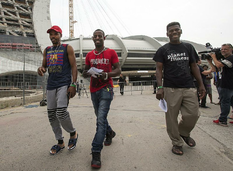 Asylum seekers from Haiti leave a temporary shelter at Olympic Stadium in Montreal on Thursday .
