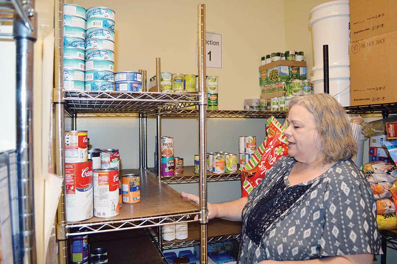 Judi Lively, executive director of Bethlehem House, a transitional homeless shelter in Conway, looks at the sparse shelves in the pantry. Lively said donations of food and money are typically down in the summer.