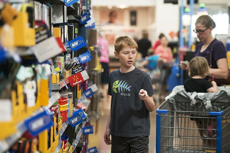 Andrew Kemp, 9, a fifth-grader at Janie Darr Elementary in Rogers, shops for school supplies this week with his mother, Holly Kemp, and sister Noelle, 2, at the Wal-Mart Supercenter on Pleasant Crossing Boulevard in Rogers.