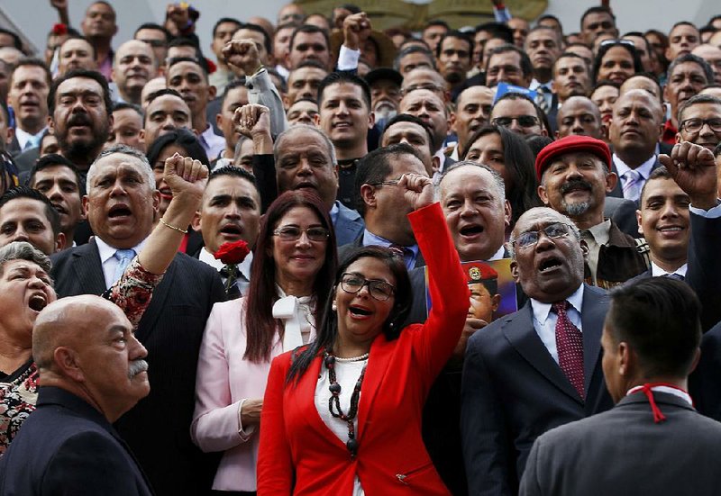 Delcy Rodriguez leads a cheer for an official photo Friday in Caracas after she was chosen as president of Venezuela’s new, all-powerful constitutent assembly. 
