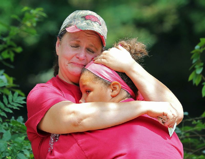 Brenda Murphy hugs her granddaughter Alexis Edgerson at the scene of a fire at 903 W. Holland Ave. in White Hall that killed two people Friday morning. A relative at the scene said Murphy was the longtime girlfriend of fire victim Tony Carruth. 