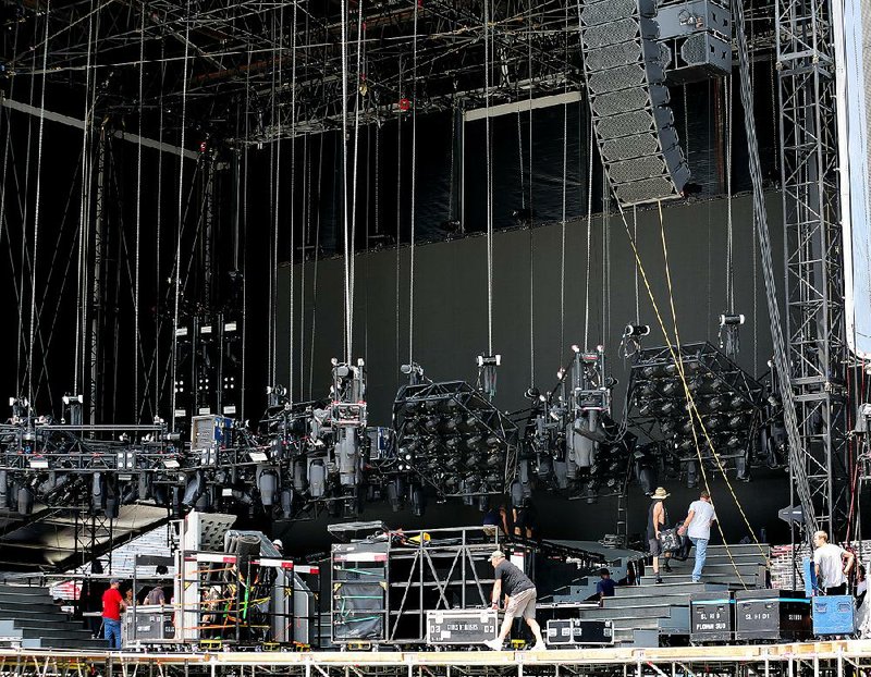 Production crew members set up the elaborate stage components Friday in preparation for tonight’s Guns N’ Roses concert at War Memorial Stadium in Little Rock. 