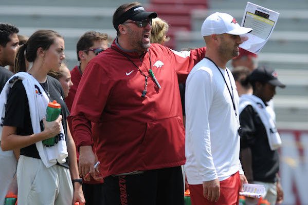Arkansas coach Bret Bielema (center) speaks to players alongside assistant coach Barry Lunney Saturday, Aug. 5, 2017, prior to the start of a scrimmage in Razorback Stadium in Fayetteville.