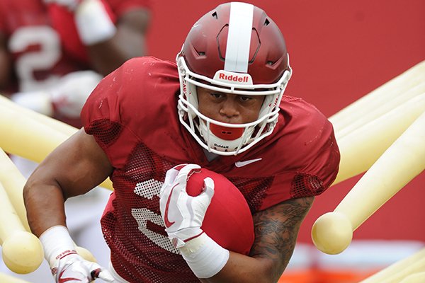 Arkansas running back Devwah Whaley carries the ball through a practice device Tuesday, Aug. 1, 2017, during practice at the university's practice field in Fayetteville.
