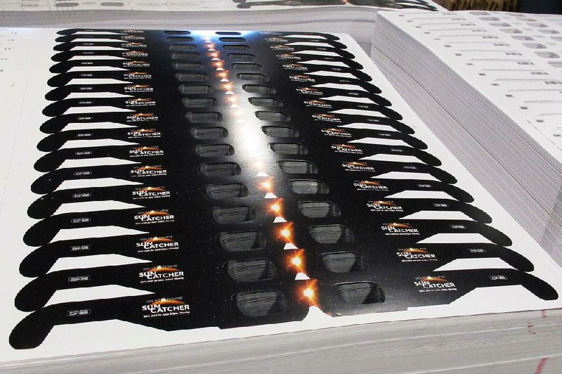 Cardboard frames for solar eclipse viewing glasses roll out at a factory in Bartlett, Tenn., in June. NASA advises using special eclipse glasses or a pinhole viewing device to look at this month’s eclipse. Regular sunglasses won’t be sufficient, even to view the partial eclipse in Arkansas.