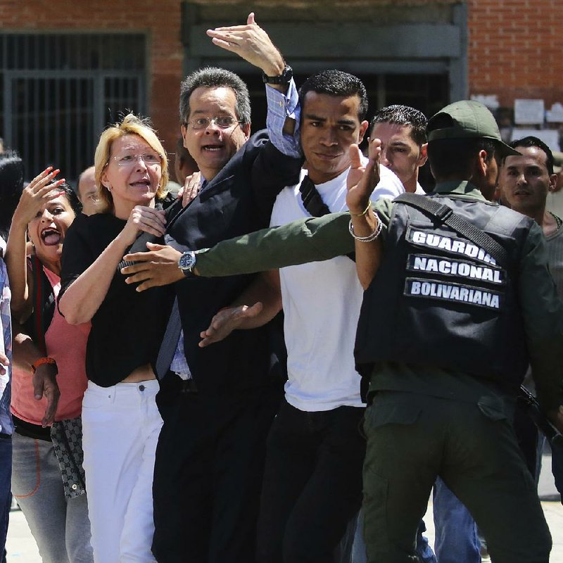 Loyal employees surround Venezuelan chief prosecutor Luisa Ortega (in white pants) as security forces block her from entering her office Saturday in Caracas after the new constituent assembly ousted her.