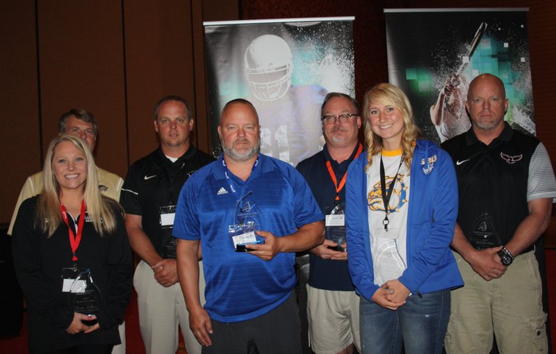 Coaches Kristin Killham, Ramay Junior High (from left); Chip Durham, Bentonville West; Jody Grant, Bentonville; Steve Peck, Rogers; Wayne Levering, Rogers Heritage; Ashley Riggles, Decatur; and Stephen Neal, Pea Ridge, are named Kendrick Fincher Hydration for Life Hydration Heroes at the Mercy Coaching Summit on July 27 at the John Q. Hammons Center in Rogers.