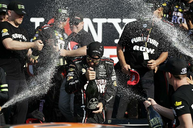 Martin Truex Jr. (center) is showered with champagne after winning Sunday’s I Love New York NASCAR Monster Energy Cup race at Watkins Glen (N.Y.) International. It was the fourth victory of the season for Truex, the series points leader, who held off Matt Kenseth on the final lap to win.