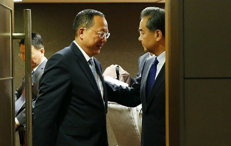 North Korean Foreign Minister Ri Yong Ho (left) and Chinese Foreign Minister Wang Yi end their meeting Sunday in Manila, Philippines.