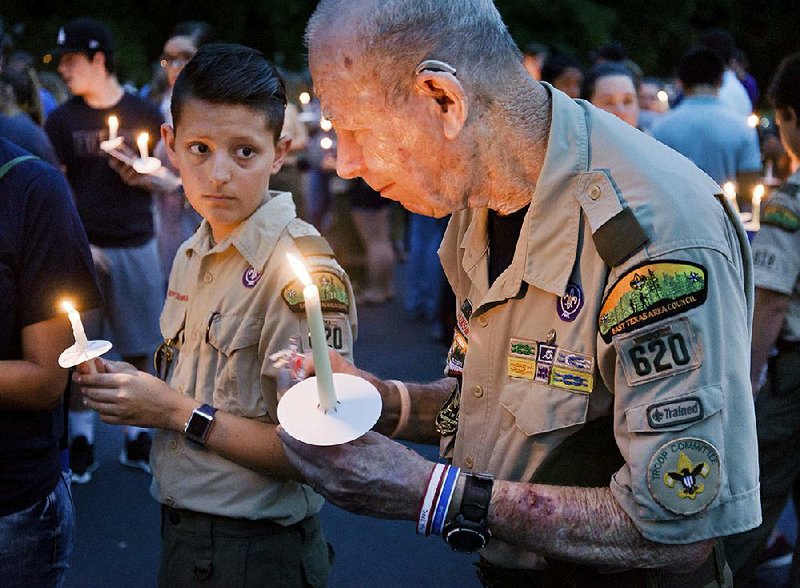 Dan Thompson (right) and Tony Little, 13, both with Troop 620, participate in a candlelight vigil Sunday in Hallsville, Texas, after a fatal Scout boating accident.
