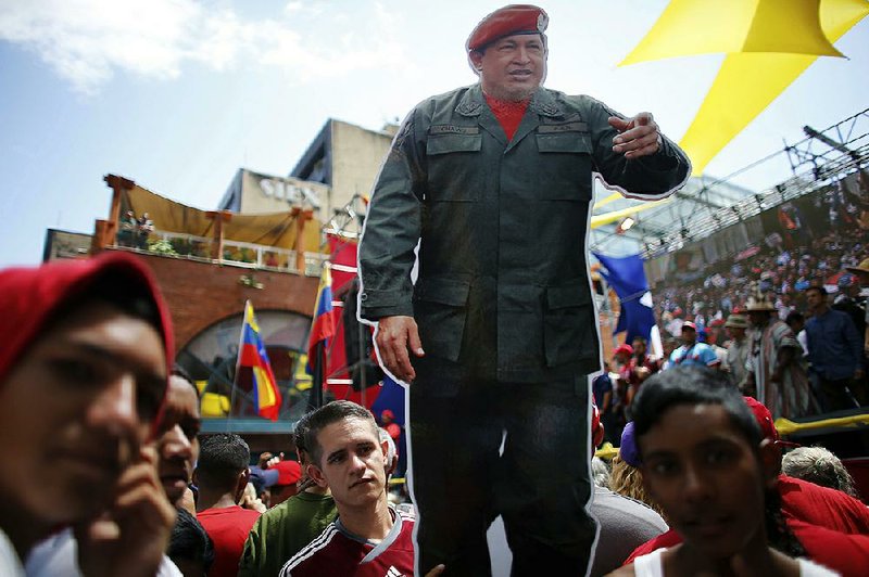 A cutout of Venezuela’s late President Hugo Chavez stands among supporters during a rally backing the the new constitutional assembly outside the National Assembly building in Caracas, Venezuela, on Monday.