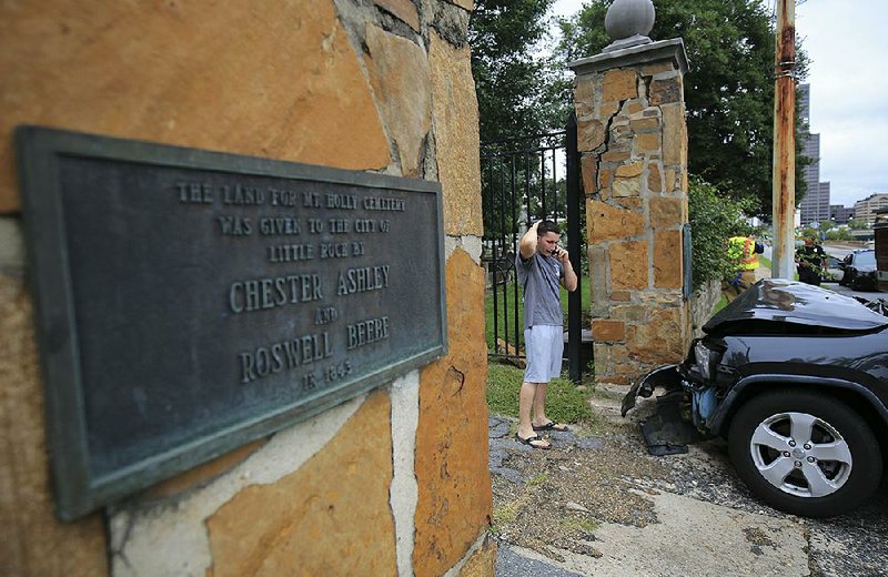Arkansas Democrat-Gazette/STATON BREIDENTHAL --8/7/17-- The driver of a vehicle that hit a column at the entrance to Mount Holly Cemetery in Little Rock talks on the phone Monday shortly after the accident. No one was injured and no other vehicles were involved in the accident. 