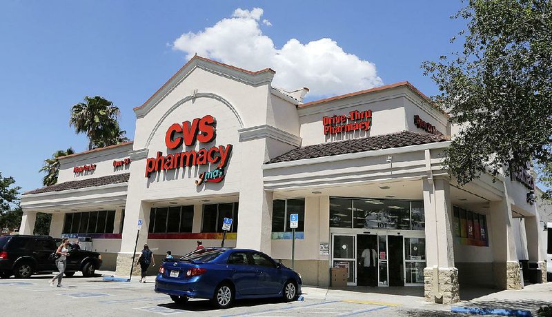CVS customers visit a store in Hialeah, Fla., in May. The pharmacy chain faces another lawsuit claiming it charged customers co-payments for certain prescription drugs that exceed the cost of medicines.  