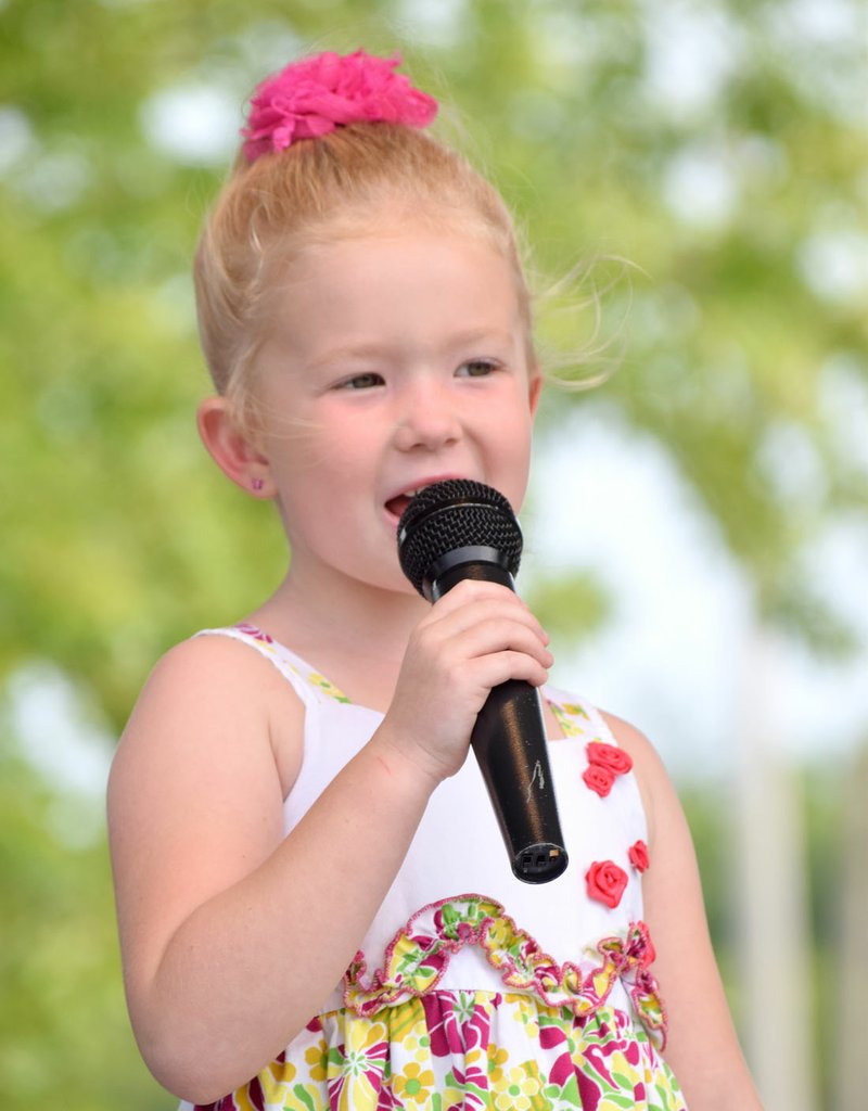 Photo by Mike Eckels Avery Helms from Gentry sings a patriotic song during the Tiny Tots Miss Decatur BBQ contest on the stage at Veterans Park in Decatur Aug. 5. Avery was the first runner-up.
