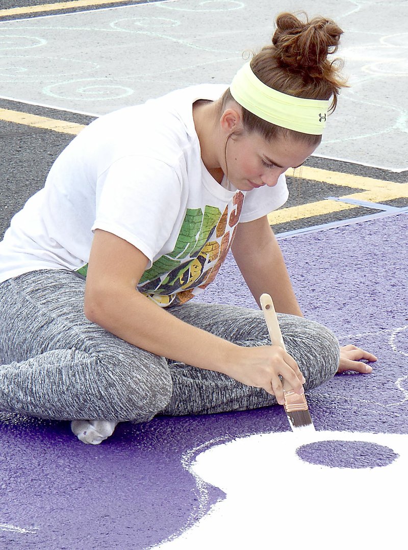 Photo by Randy Moll Meledy Owens, 16 and a sophomore at Gentry High School, painted a design on her assigned parking space at the high school on Aug. 2. Students are allowed to paint their assigned parking spaces for a fee, which goes to the student council to help pay for the homecoming dance.