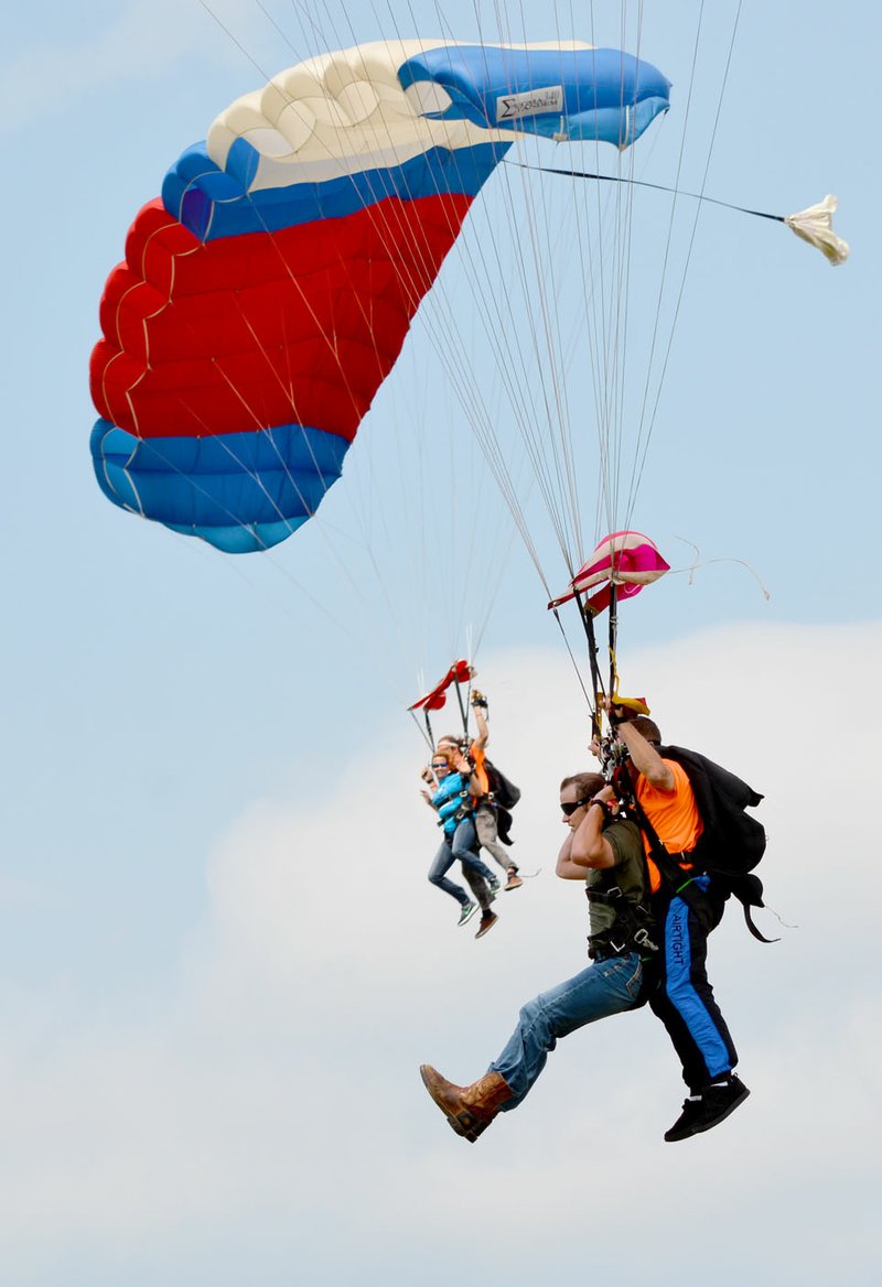 Michael Burchfiel/Herald-Leader A pair of participants prepared to touch down during their dives at the SkyDive for Kids event on Saturday. Skydivers raised money for the Children&#8217;s Advocacy Center of Benton County.