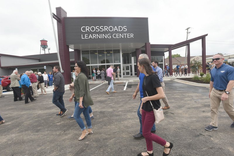 NWA Democrat-Gazette/FLIP PUTTHOFF Guests arrive Tuesday for a dedication of Crossroads Learning Center in downtown Rogers.