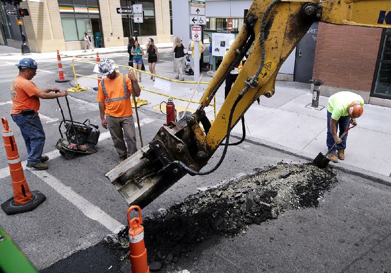 A crew works on a street in downtown Boston in June. Labor costs edged up 0.6 percent in the second quarter, along with a modest rise in worker productivity. 