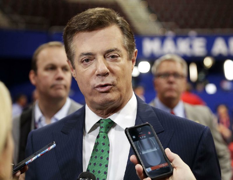  In this July 17, 2016 file photo, then Trump Campaign Chairman Paul Manafort talks to reporters on the floor of the Republican National Convention at Quicken Loans Arena in Cleveland as Rick Gates listens at back left. 