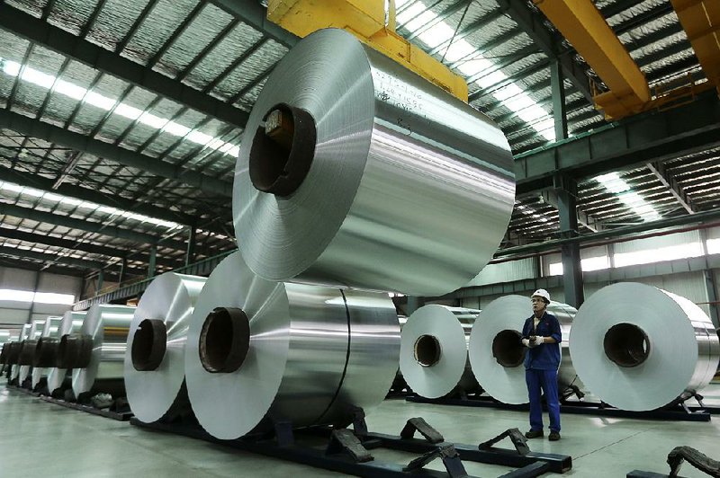 A worker arranges rolls of aluminum at a factory in China’s Anhui province. The United States plans to levy an import tax of up to 81 percent on aluminum foil from China. 