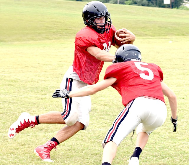 Photo by Rick Peck Kennedy Hodson uses a stiff arm in an attempt to avoid a tackle after catching a pass during the McDonald County High School football team&#8217;s first intrasquad scrimmage held Saturday at MCHS.