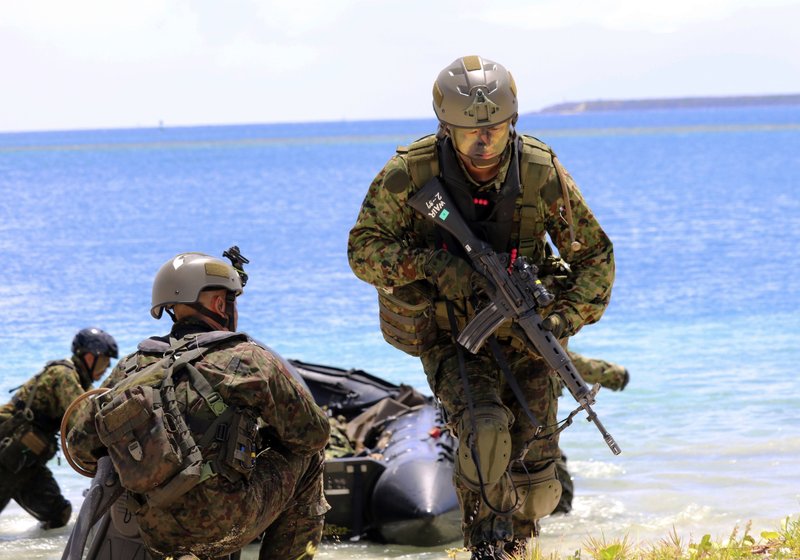 FILE - In this May 13, 2017 file photo, Japanese soldiers use rubber rafts as part of an amphibious drill during joint military exercises between the U.S., Japan, France and the United Kingdom, on Naval Base Guam. North Korea says it is examining its operational plans for attacking Guam to contain U.S. bases there.  (AP Photo/Haven Daley, File)