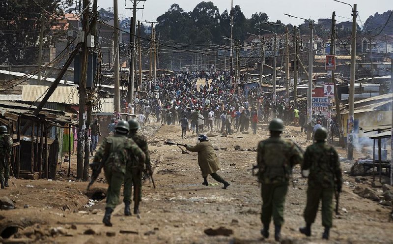 Riot police fire tear gas at protesters throwing rocks during clashes Thursday in the Kawangware slum of Nairobi, Kenya.