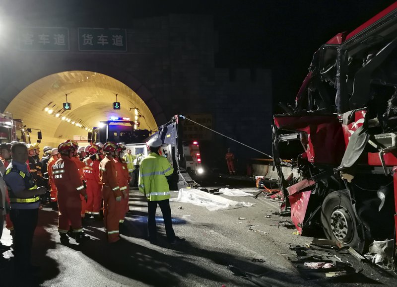 In this photo released by China's Xinhua News Agency, first responders work at the site of an accident after a coach hit the wall of the Qinling Mountains No. 1 Tunnel on the Jingkun Expressway in Ningshan County, northwestern China's Shaanxi Province, Friday, Aug. 11, 2017. The passenger coach crashed into the wall of the expressway tunnel in China's northwest, killing dozens and injuring others, official media reported Friday. (Xinhua via AP)