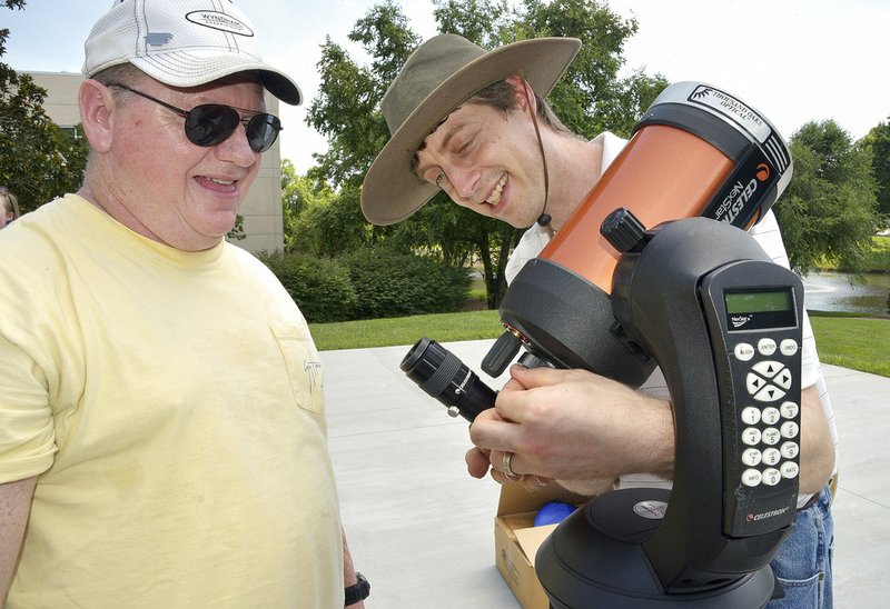  In this June 29, 2017 file photo, David Chrismon, left, a member of Guilford Technical Community College's student astronomy club, the Stellar Society, watches as Steve Desch, an astronomy instructor, sets up a telescope in Jamestown, N.C., that the group will use on their trip to Newberry, S.C. to observe a solar eclipse on Aug. 21. 