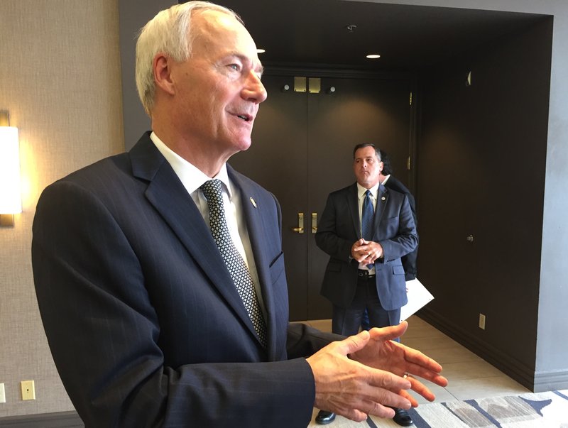 Gov. Asa Hutchinson speaks to reporters from the Little Rock Marriott Hotel on Friday, Aug. 11.