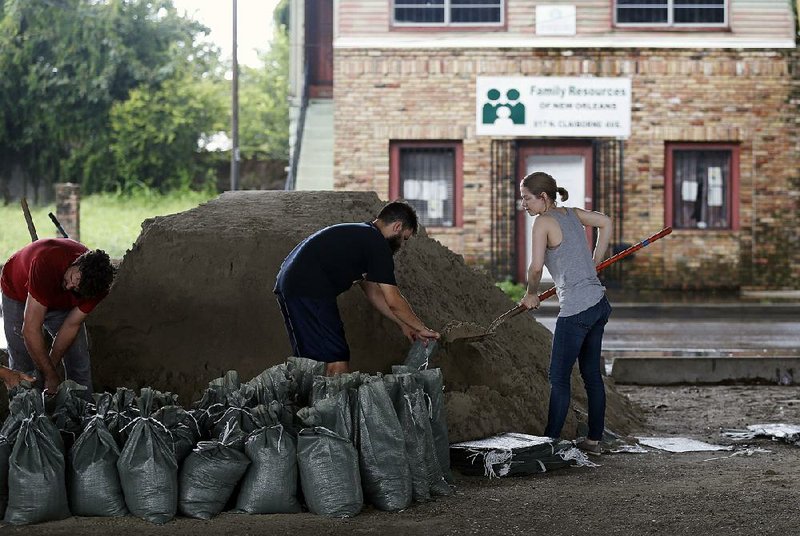John Flemming and Andrea Dube fill sandbags Friday in New Orleans as the threat of more "ooding from rainstorms kept the city on edge. One resident said the potential for "ooding and the fear that pumps could be overwhelmed are “bringing back Katrina memories.” 
