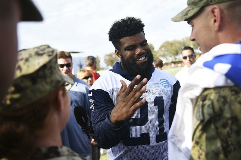 Dallas running back Ezekiel Elliott talks to a fan after practice at training camp in Oxnard, Calif., on Friday. The NFL suspended him for the first six games of the season for domestic abuse.