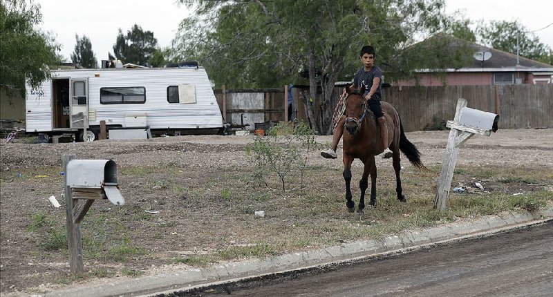 A boy rides through Indian Hills East colonia near Alamo, Texas, last month. Texas has more than 2,300 colonias that have sprung up around towns and are home to Hispanic immigrant families. 