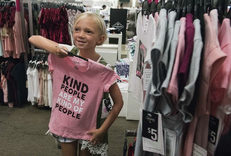 Kenadi Wade, 7, shops this week with her grandparents at a J.C. Penney store in Tyler, Texas. Though Penney reported a quarterly loss Friday of $62 million, the department store chain said back-toschool sales were off to a “good start.” 