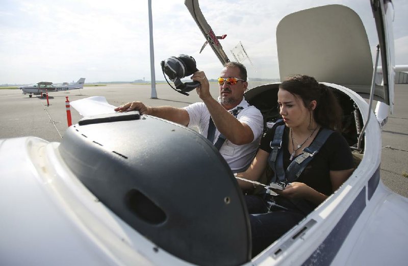 Flight instructor Jeff Harless (left) and student Grace Harrison, 19, finish pre-flights checks before a training flight Thursday at Central Flying Service. A ceremony Wednesday will mark 475,000 flight training hours completed by Central Flying Service’s flight training division.