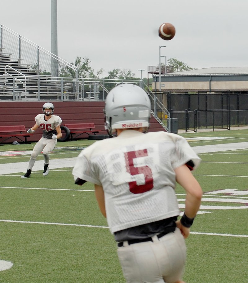 Graham Thomas/Siloam Sunday Siloam Springs senior receiver Tristan Moose, No. 26, awaits the pass from sophomore quarterback Taylor Pool during the Panthers&#8217; football practice on Monday, Aug. 7, at Panther Stadium. The Panthers&#8217; practice outside on Friday morning was cut short because of a thunderstorm, but the team finished its time with a weight-lifting session.