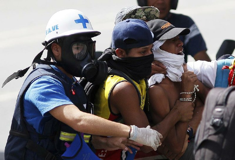 A man injured during a Caracas demonstration against Venezuela’s President Nicolas Maduro is evacuated Saturday. 