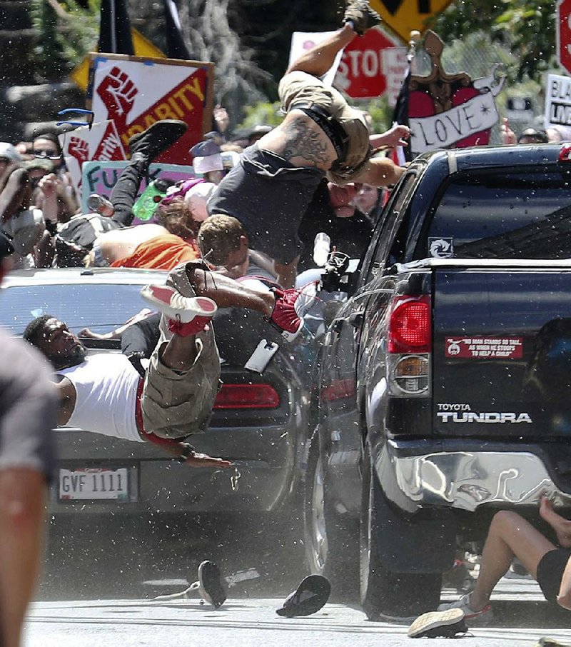 A car sends people flying Saturday as it plows into a crowd after a protest against white nationalists in Charlottesville, Va. The driver was arrested, officials said. 